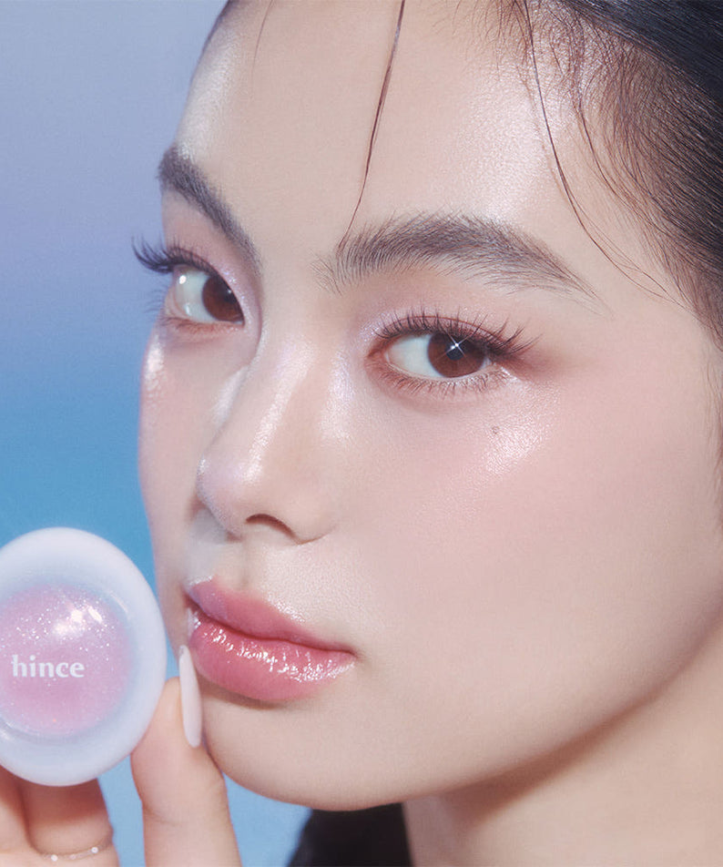 Portrait maquillage éclatant avec HINCE Low Glow Dewy Ball (Lip & Cheek) sur les lèvres, teinte rosée, fond bleu