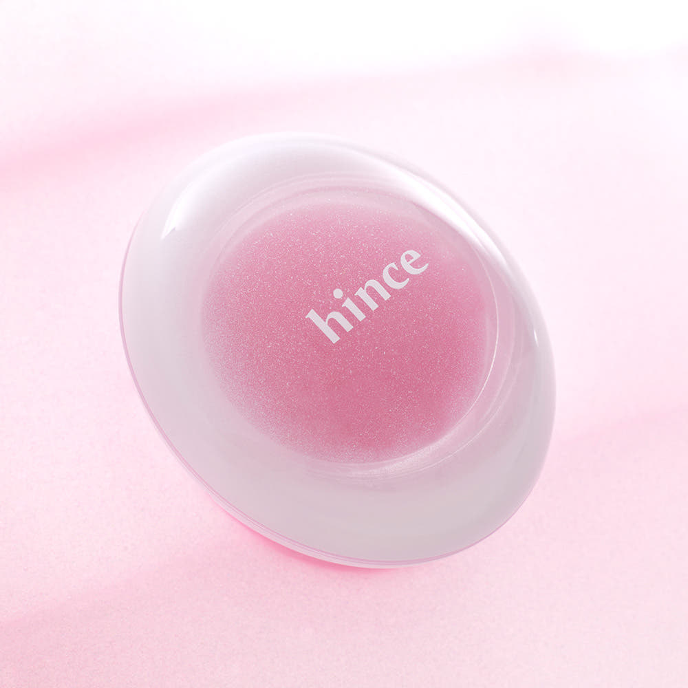 HINCE Low Glow Dewy Ball (Lip & Cheek) de HINCE, balle rosée en contexte maquillage sur fond rose clair.