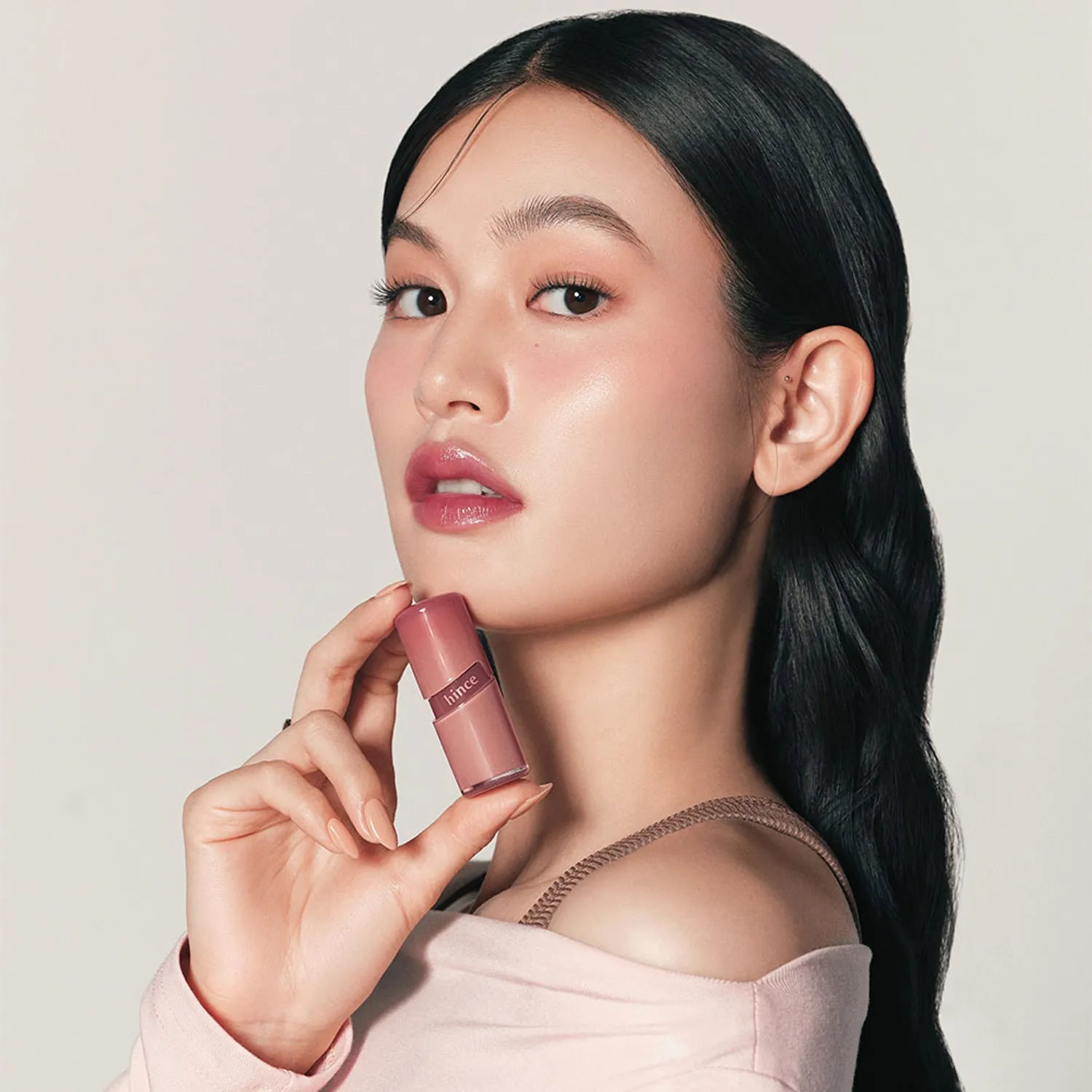 HINCE  Raw Glow Gel Tint, femme tenant le gel tint, maquillage glow, fond clair minimal, publicité beauté HINCE.