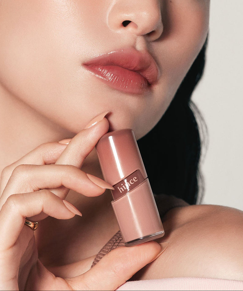 HINCE  Raw Glow Gel Tint, femme maquillée appliquant le gel tint sur les lèvres, lumière studio, gros plan