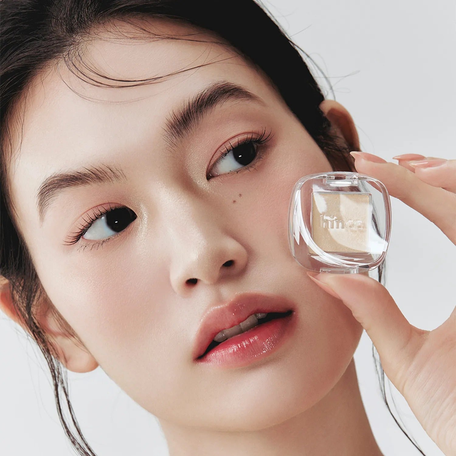 HINCE Single Eyeshadow : maquillage des yeux sur fond blanc, packaging transparent tenu par une femme, marque HINCE