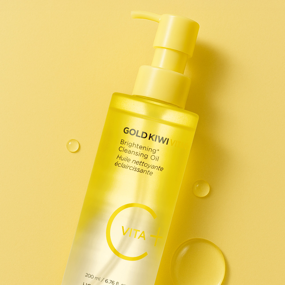Décris l'image en français en mentionnant le produit, la marque et le contexte visuel : HOLIKA HOLIKA Gold Kiwi Vita C+ Brightening Cleansing Oil 200ml sur fond jaune.