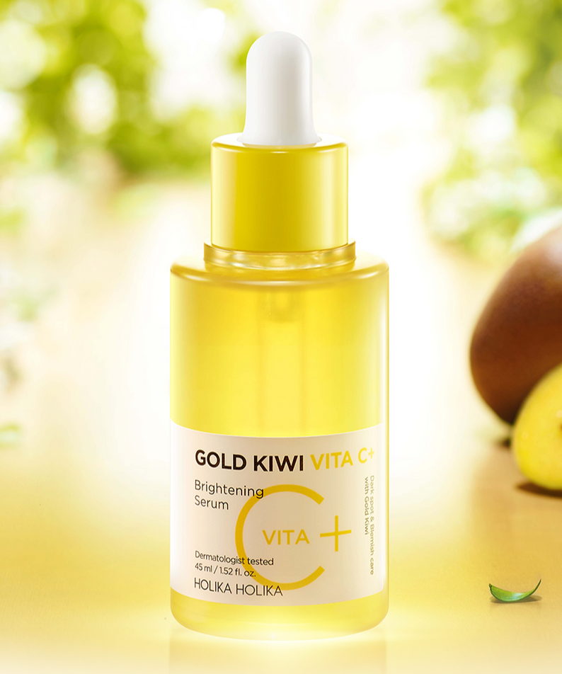 Décris l'image en français: HOLIKA HOLIKA Gold Kiwi Vita C+ Brightening Serum 45ml, flacon jaune, kiwi et soleil en arrière-plan.