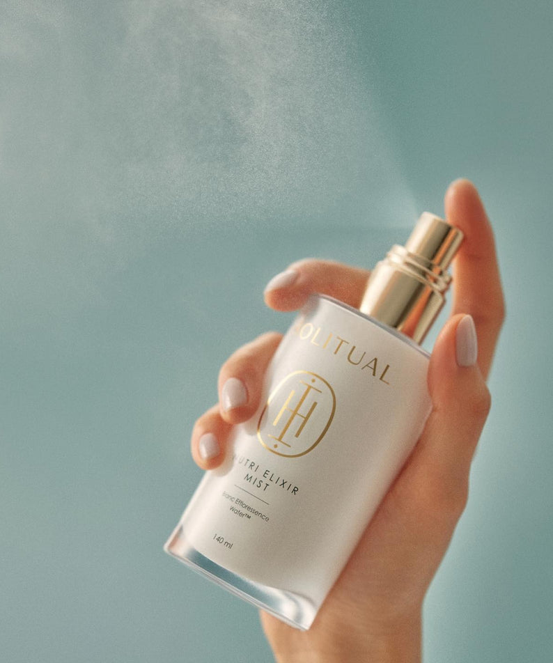 HOLITUAL  Elixir Mist 140ml, brume visage en flacon tenu dans la main sur fond bleu clair