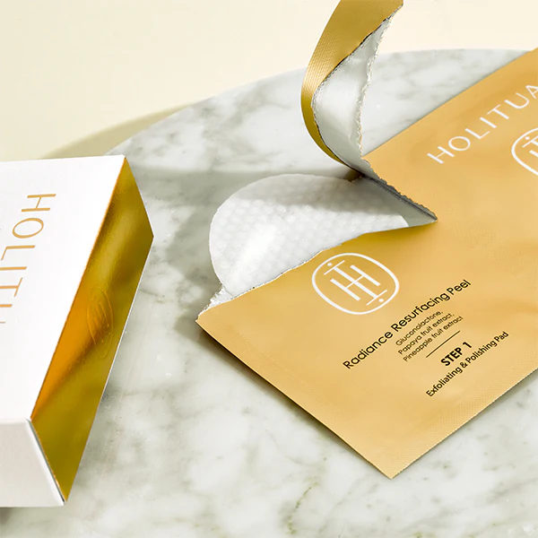 HOLITUAL Radiance Resurfacing Peel, peau exfoliante de la marque HOLITUAL, étui doré sur marbre blanc