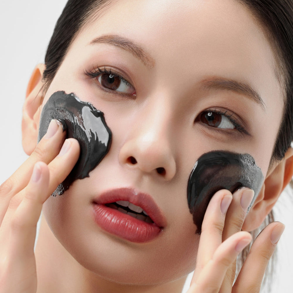 HOUSE OF HUR Midnight Soothing Cleansing Balm : une femme applique le baume noir de la marque sur le visage, soins visage.