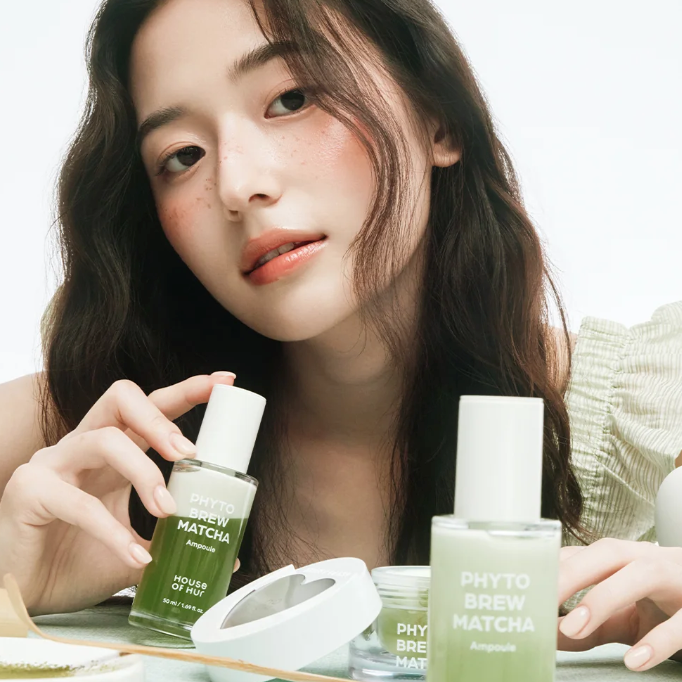 HOUSE OF HUR Phytho Brew Matcha Ampoule 50ml : femme tenant une ampoule verte, pack et bouteilles sur table.