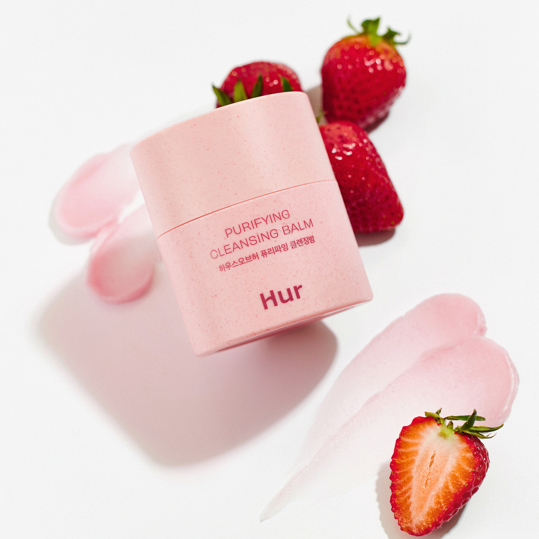 HOUSE OF HUR Purifying Cleansing Balm, pot rose sur fond blanc avec fraises; cosmétique visage nettoyant.