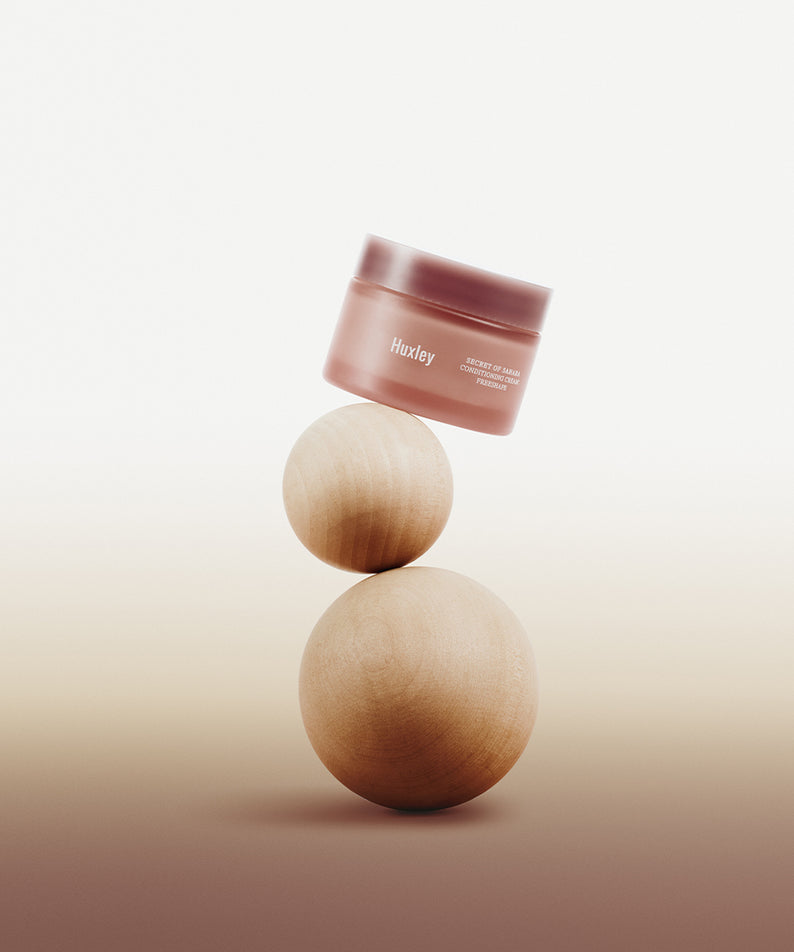Pot de HUXLEY Conditioning Cream Preshape flottant au-dessus de sphères en bois, soin de la peau haut de gamme.