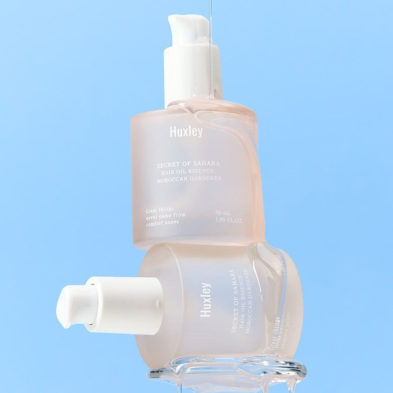 HUXLEY Hair Oil Essence Moroccan Gardener 50ml, flacon sur fond bleu, huile capillaire marque Huxley en contexte visuel