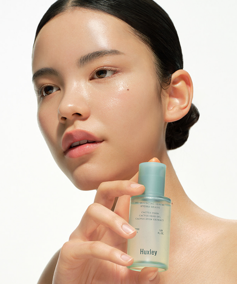 HUXLEY Rebouncing Serum Hydro Shade 50ml, sérum hydratant visage sur femme tenant le flacon, esthétique skincare.
