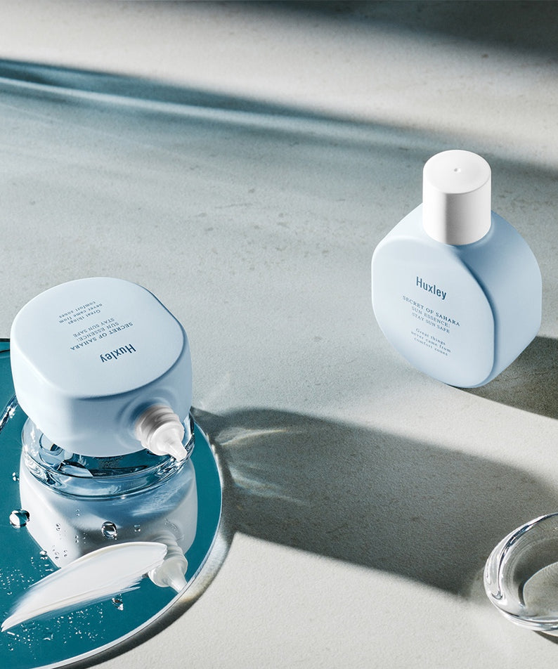 HUXLEY Sun Essence Stay Sun Safe, protection solaire élégante présentée sur un fond esthétique, flacons élégants et minimalistes.