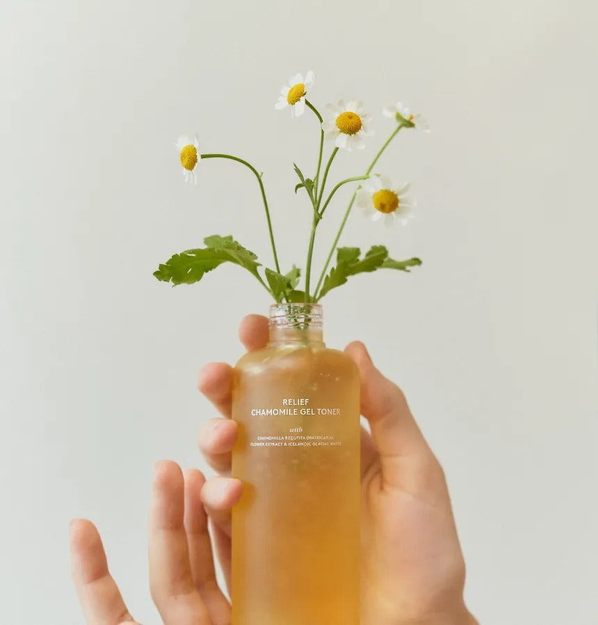 HYGGEE Relief Chamomile Gel Toner 200ml, flacon tenu avec fleurs de camomille sur fond clair, marque HYGGEE, soin apaisant