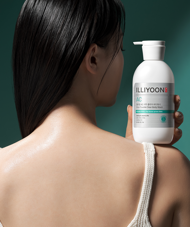 ILLiyoON Cica Acne Clear Body Wash 400ml, bouteille de soins pour peau aux tendances, sur fond vert avec personne en gros plan.
