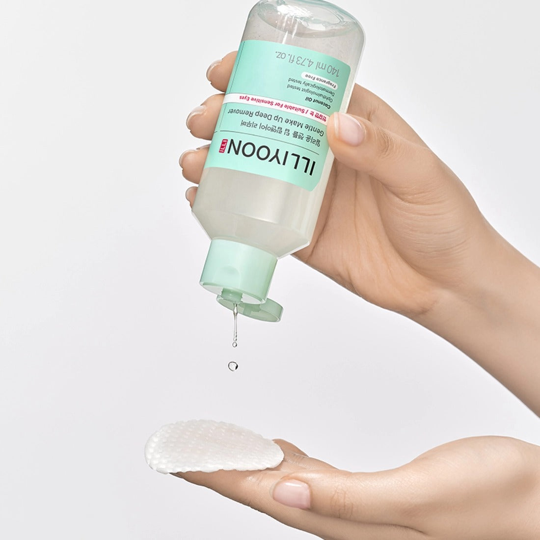 ILLIYOON Gentle Deep Lip & Eye Remover 140ml, main tenant le flacon, contour des doigts avec produit sur fond blanc