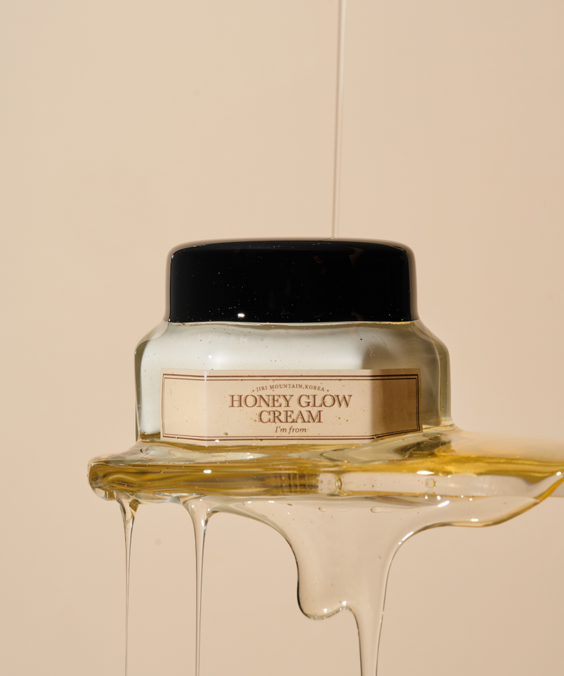 Crème I'M FROM Honey Glow 50g sur fond artistique avec miel coulant, produit de soin hydratant et éclatant.