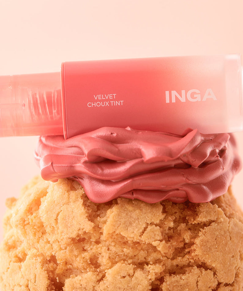 Rouge à lèvres INGA Velvet Stain posé sur une crème rose, offrant une teinte veloutée et luxueuse.