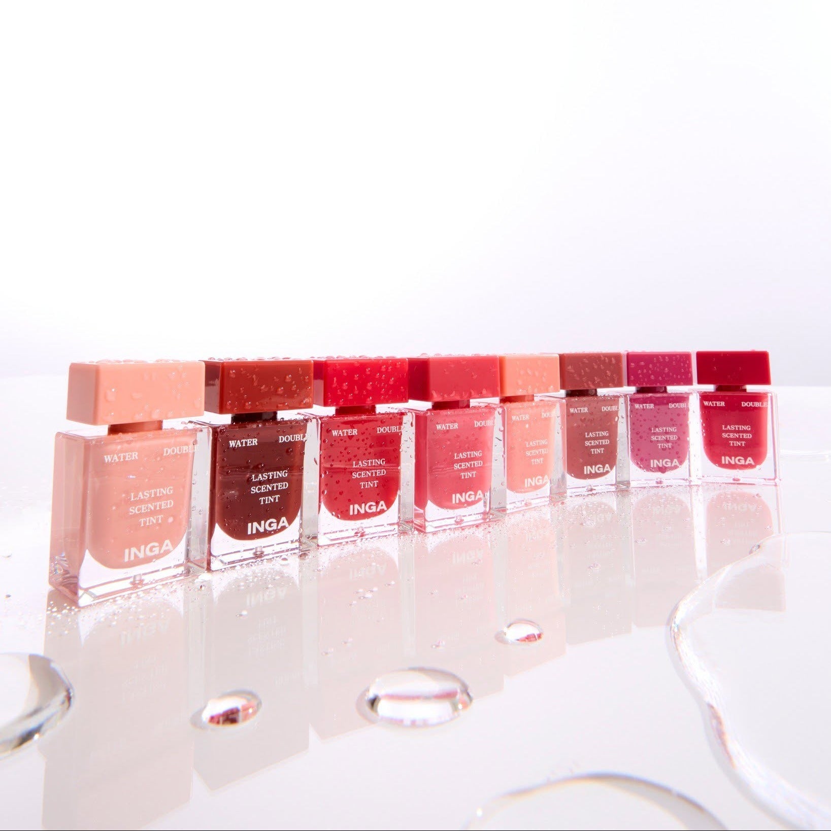 INGA Water Double Lasting Scented Tint 4.3g, marque INGA, produits colorés sur présentoir en vitrine, fond clair.