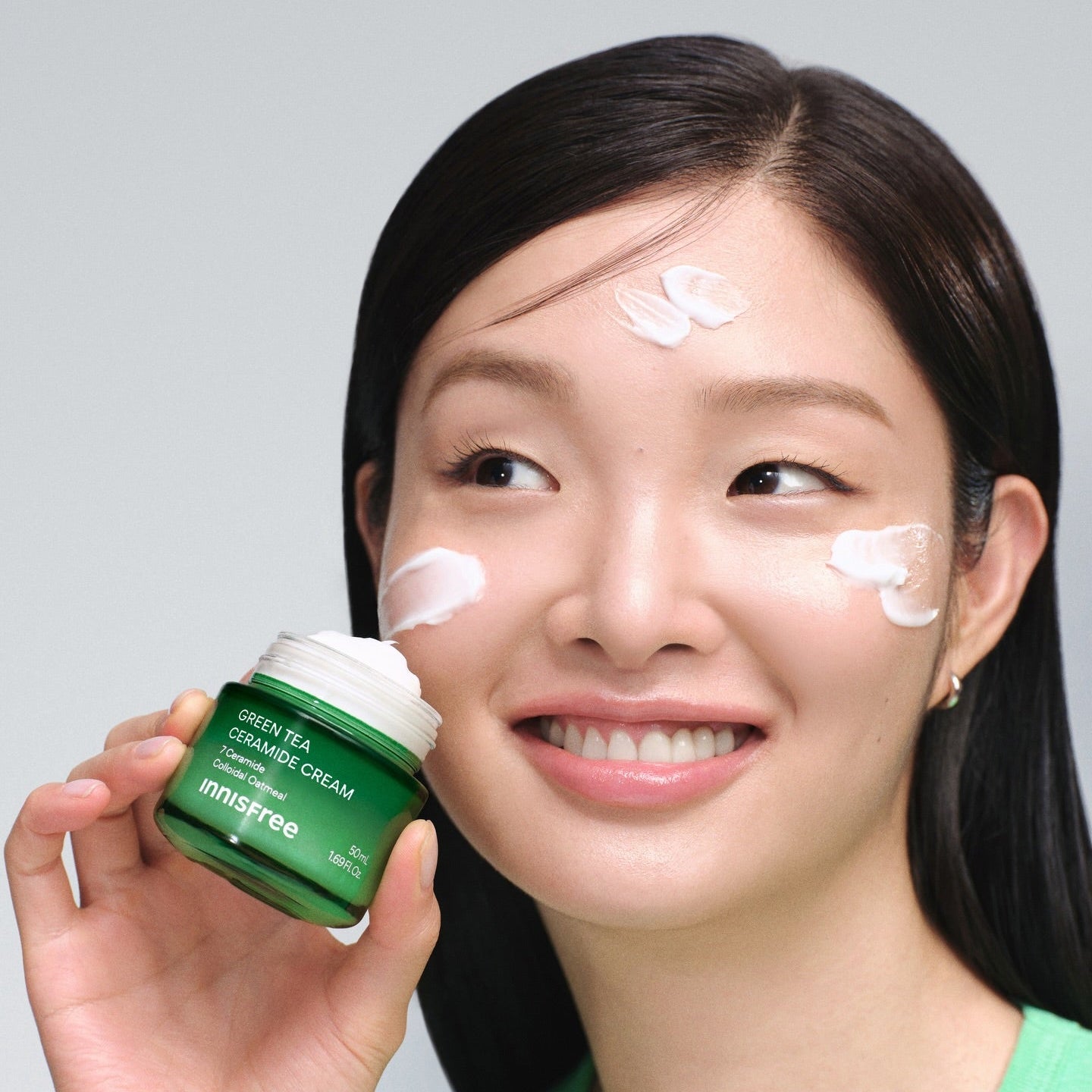 INNISFREE Green Tea Ceramide Cream 50ml : pot vert INNISFREE tenu par une femme, peau hydratée, contexte studio