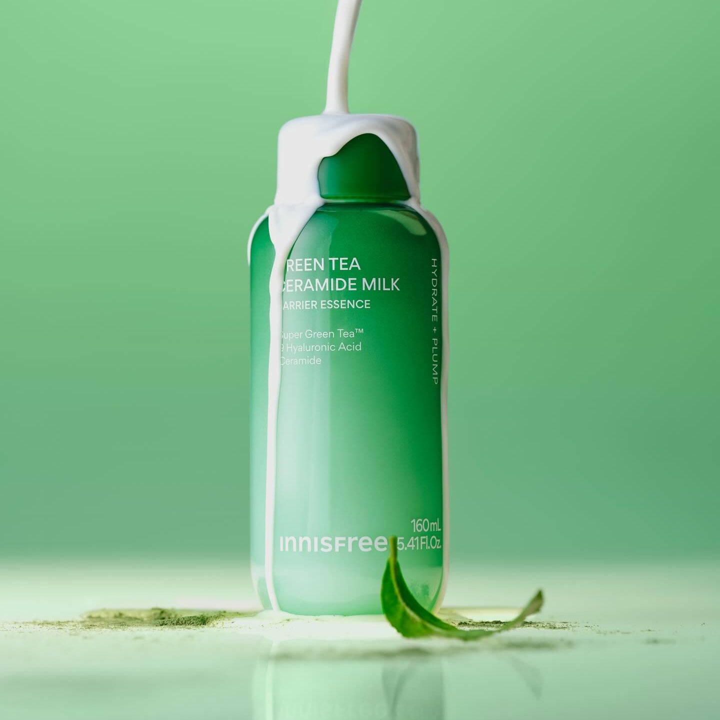 INNISFREE Green Tea Ceramide Milk Essence 160ml, bouteille en verre verte sur fond vert, feuilles de thé en contexte visuel.