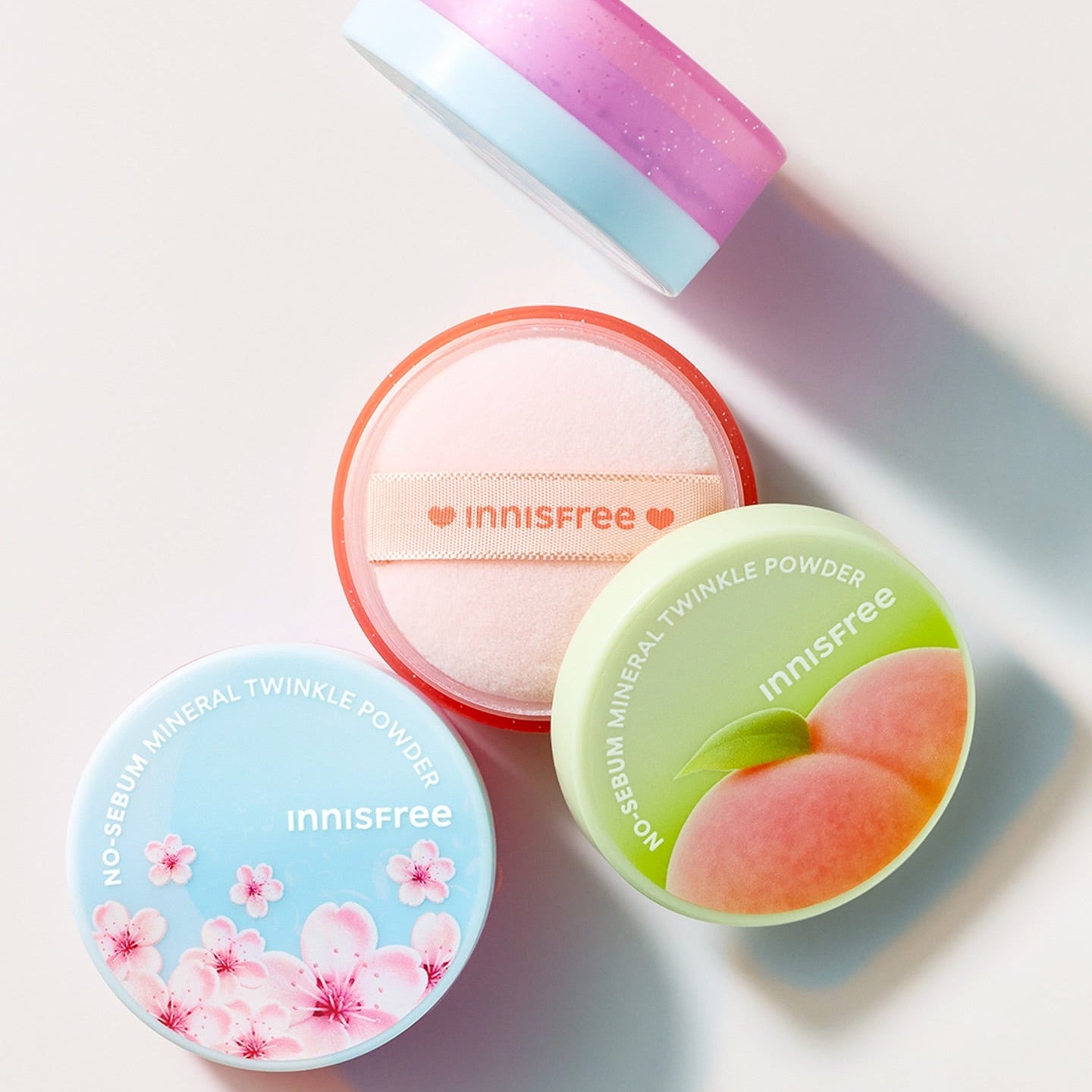 INNISFREE No Sebum Mineral Powder (5g) INNISFREE : boîtes poudre minérale sur fond clair, éclats pastels