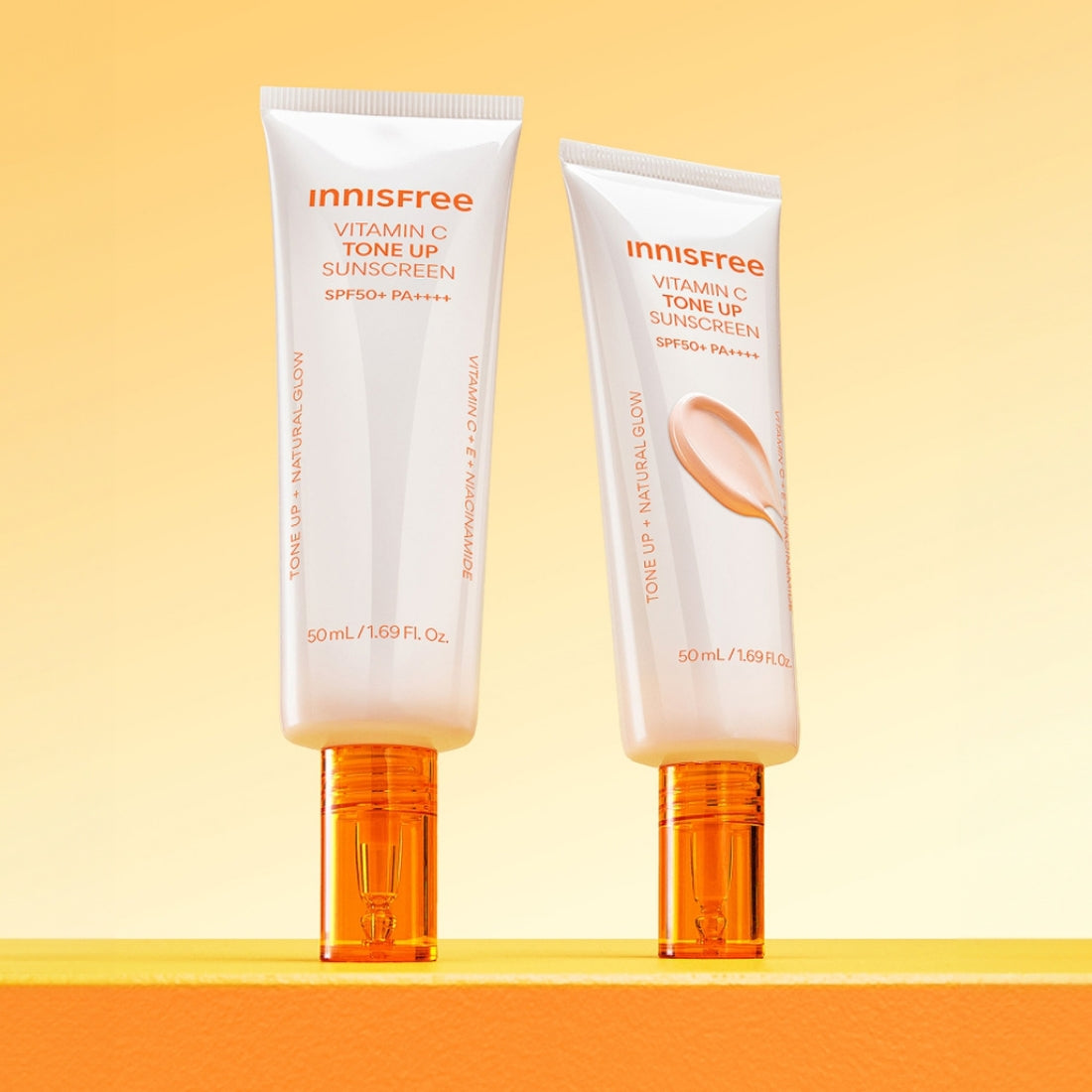 INNISFREE Vita C Spot Tone Up Sunscreen SPF50+/PA++++ 50ml, crème solaire Innisfree sur fond jaune ensoleillé.