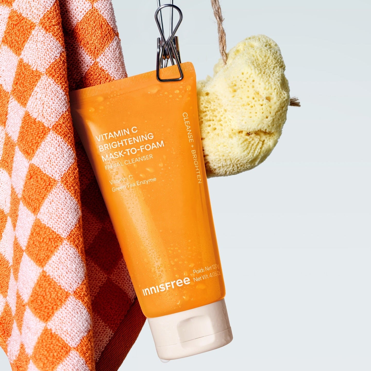 INNISFREE Vitamin C Brightening Pack-to-Foam 120g de la marque Innisfree, sur serviette orange et éponge, contexte salle de bain.