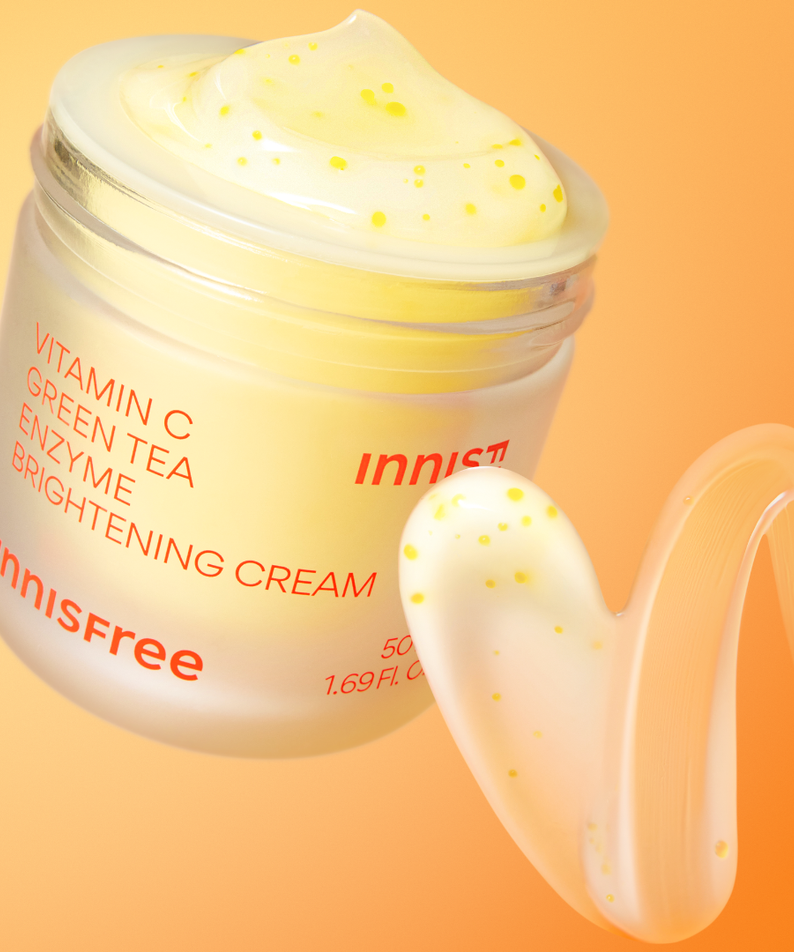 INNISFREE Vitamin C Enzyme Brightening Cream 50ml, pot crème lumineux sur fond orange avec éclats de vitamine C.