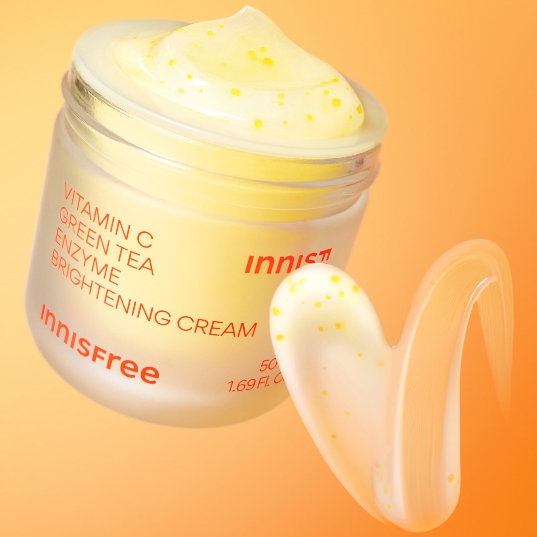 INNISFREE Vitamin C Enzyme Brightening Cream 50ml, pot crème lumineux sur fond orange avec éclats de vitamine C.