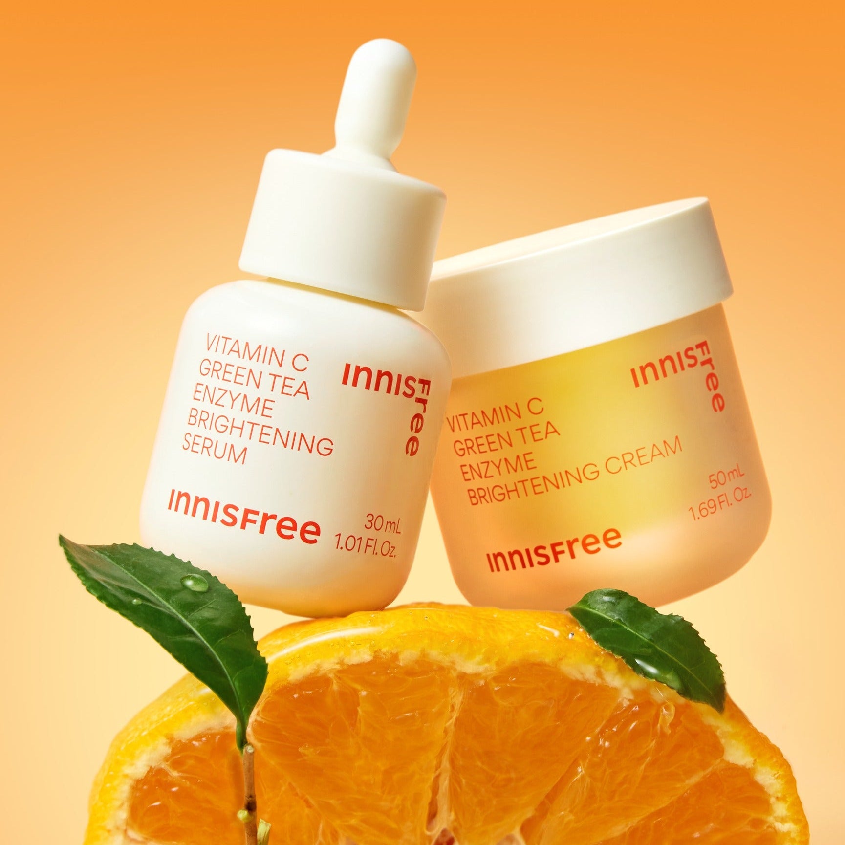 INNISFREE Vitamin C Enzyme Brightening Cream 50ml, pot sur fond orange avec feuilles et agrume, ambiance soin visage