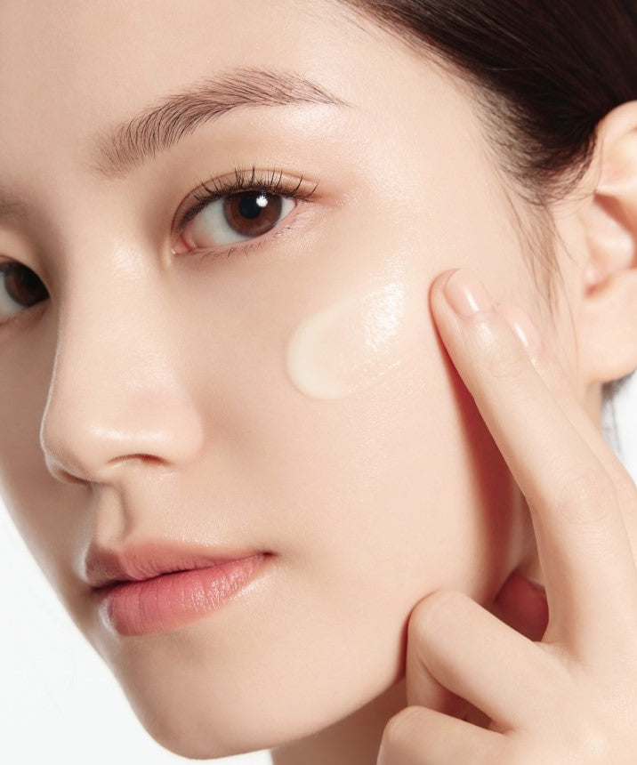 Modèle visage appliquant IOPE Retinol Expert 0.1% Wrinkle Corrector 30ml Set, peau lissée, marque IOPE, fond clair.