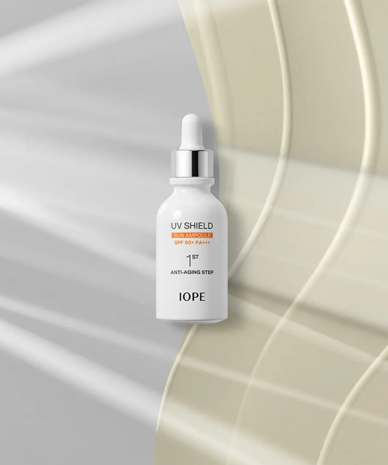 IOPE UV Sheild Sun Ampoule SPF 50+PA+++ 40ml, flacon sérum anti-âge, sur décor lumineux abstrait, ambiance soins beauté