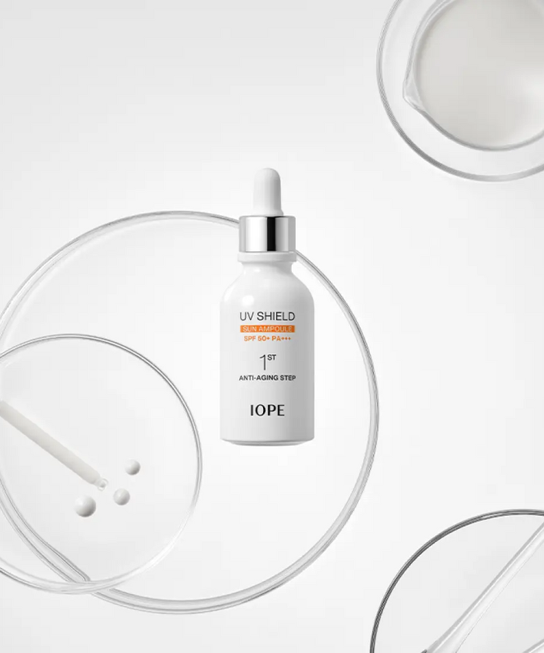 IOPE UV Sheild Sun Ampoule SPF 50+PA+++ 40ml, flacon IOPE sur fond blanc avec éléments UV, flèches et gouttes.