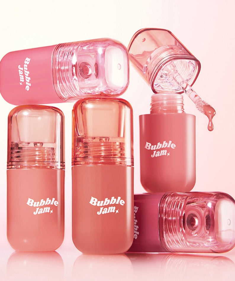 IPKN Bubble Jam Gloss, tubes brillants rose en arrière-plan pastel, photos produit de la marque IPKN.