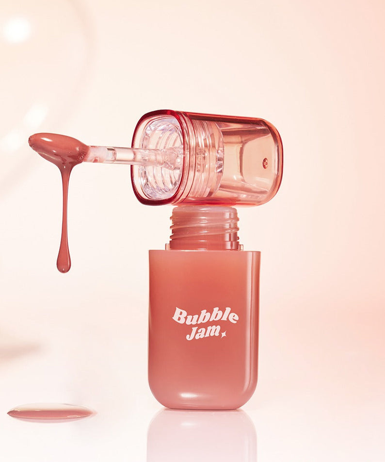 IPKN Bubble Jam Gloss, flacon rouge à effet bubble, gros plan sur fond beige, texture brillante de maquillage