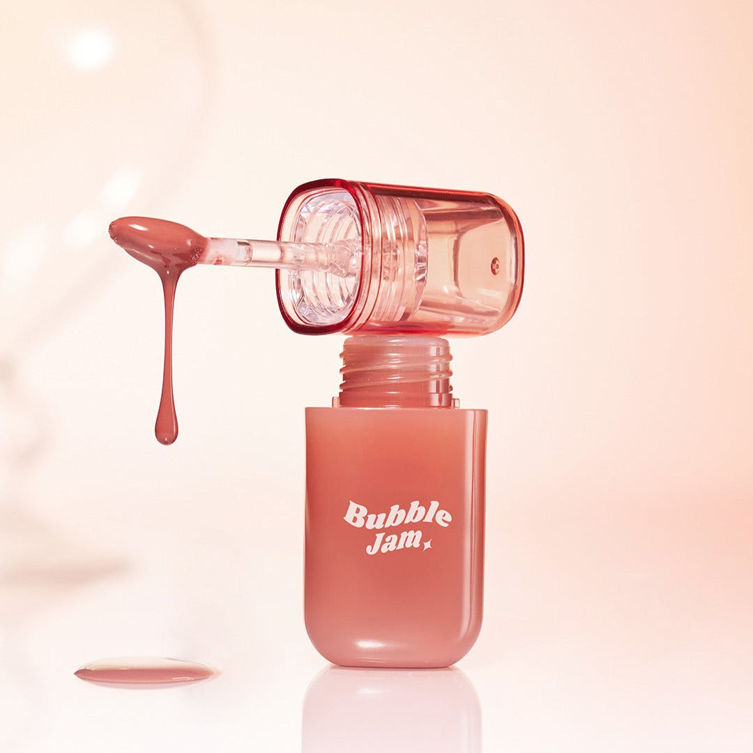 IPKN Bubble Jam Gloss, flacon rouge à effet bubble, gros plan sur fond beige, texture brillante de maquillage