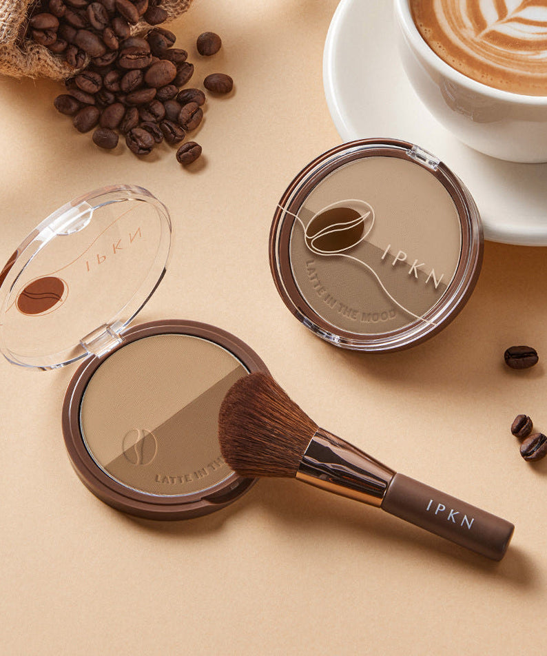 IPKN  Latte in the Mood Contouring de la marque IPKN, poudre et pinceau, scène café avec grains de café.
