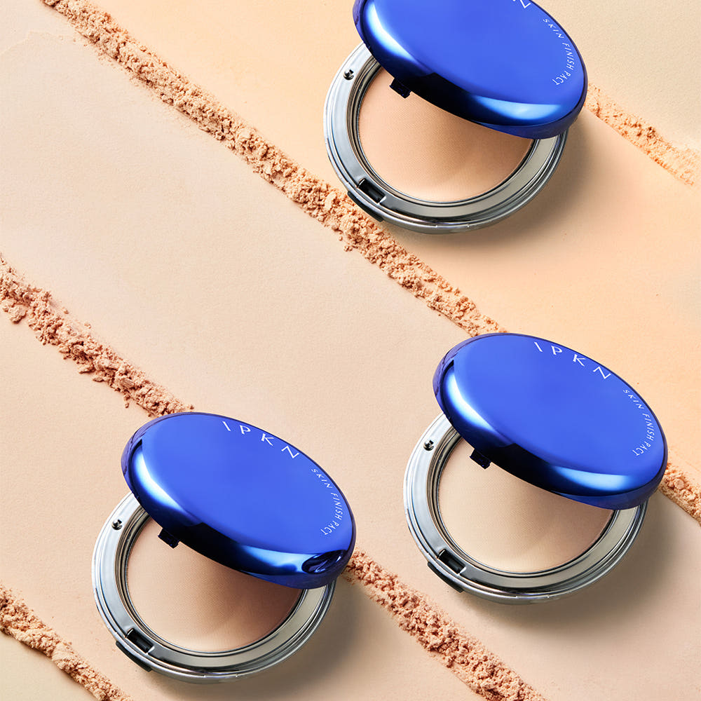 IPKN  Skin Finish Powder Pact (Main Product 14g + Refill 11g) en poudre, étui bleu sur fond beige, visuel maquillage