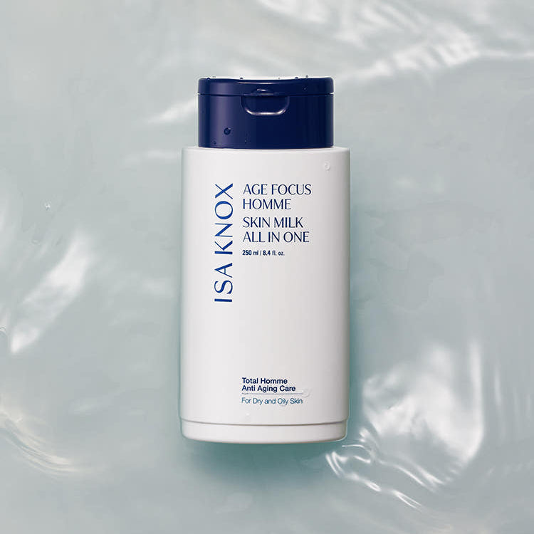ISAKNOX  Age Fous Homme Skin Milk All-in-One 250ml, flacon blanc et bleu sur fond satin lumineux.
