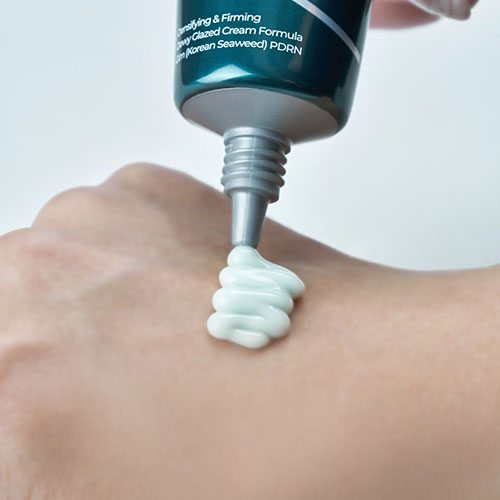 ISNTREE Kim PDRN Hydro Firming Cream 50ml, tube appliqué sur peau, crème hydro-résistante, gros plan.