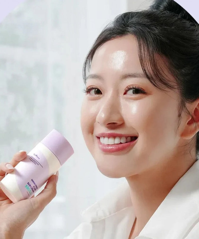 Femme souriant tenant le ISNTREE Onion fresh Fluid Sun Cream 50ml pour une peau saine et protégée.
