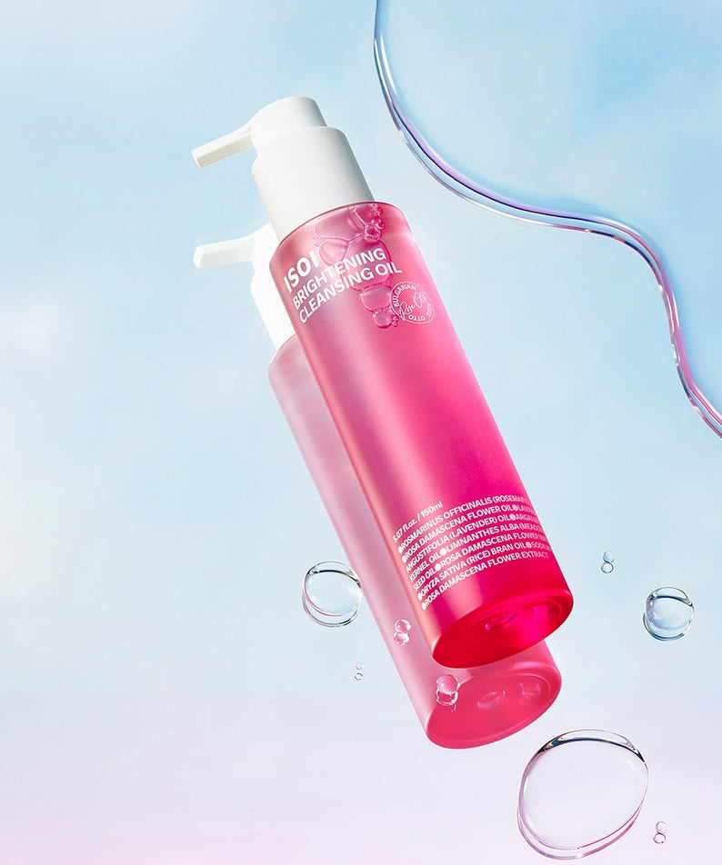ISOI Brightening Cleansing Oil 150ml, flacon rose ISOI sur fond bleu clair, gouttes d’eau et esthétique skincare