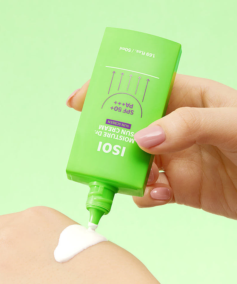 Main tenant ISOI Moisture Doctor Sun Cream SPF50+PA+++ 50ml de la marque ISOI, crème solaire sur peau, fond vert