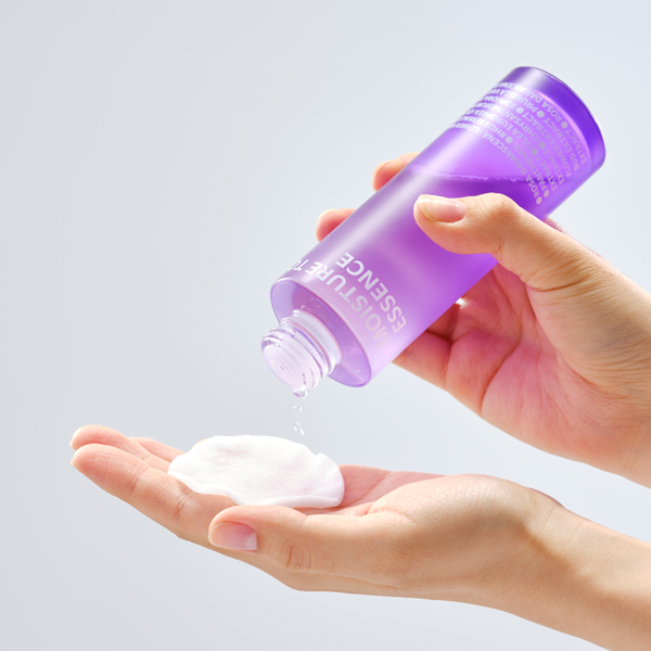 ISOI Moisture Tonic Essence 130ml de marque ISOI, main appliquant le produit sur la paume, contexte soin beauté.