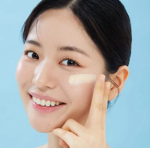 ISOI Skincare Vegan Tone-Up Sun SPF38, PA++ 40ml sur un visage avec mains, peau lumineuse, fond bleu.