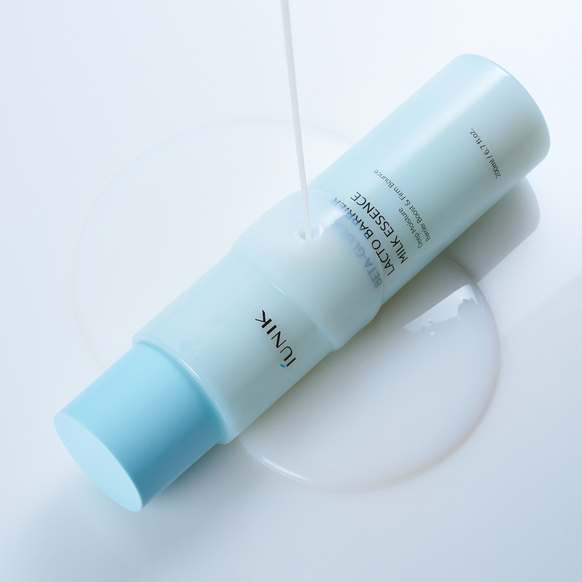 IUNIK Beta Glucan Lactobarrier Milk Essence 200ml : flacon crème lactée bleu sur fond blanc, contexte skincare.