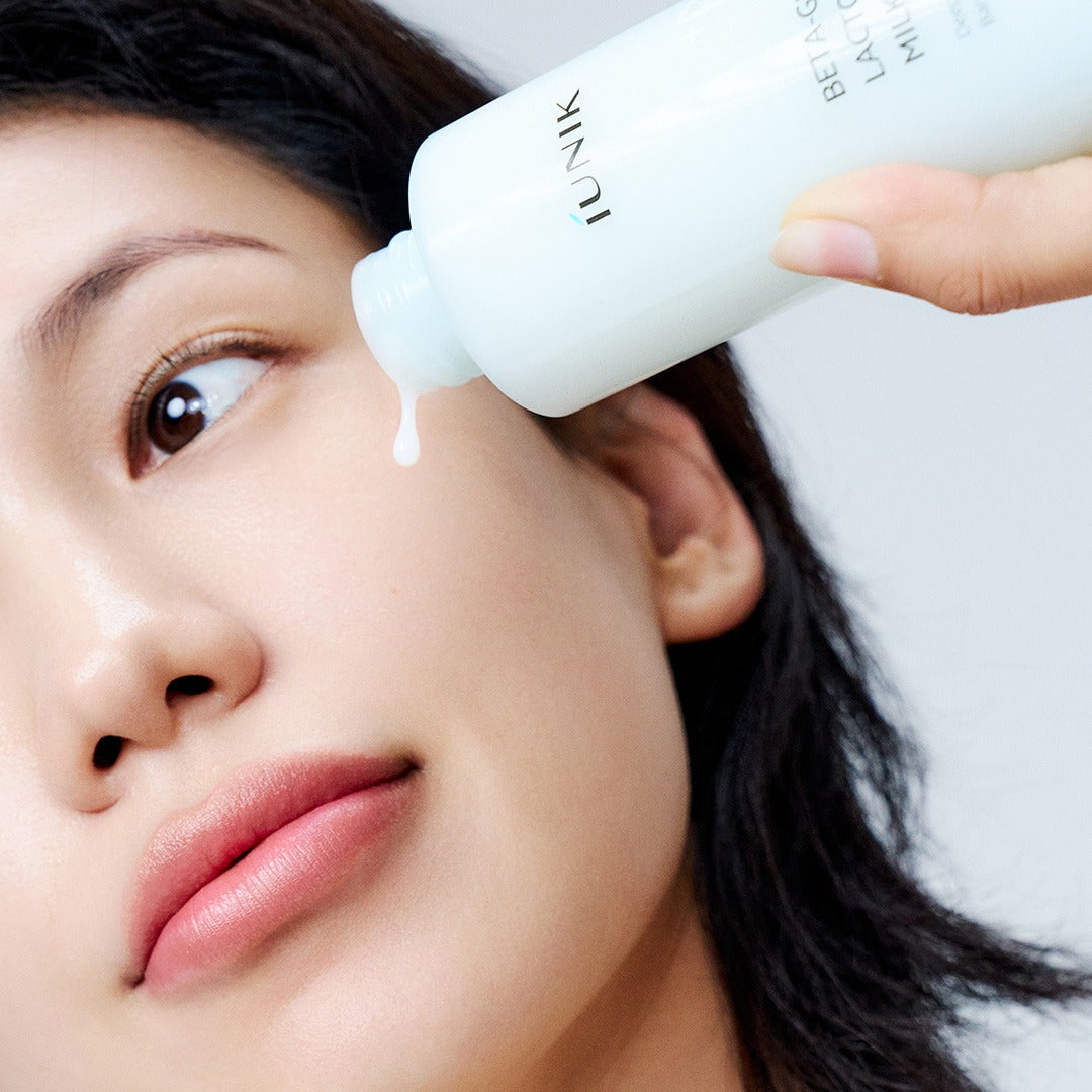 IUNIK Beta Glucan Lactobarrier Milk Essence 200ml, flacon appliqué sur le visage d’une femme, marque IUNIK, soin beauté