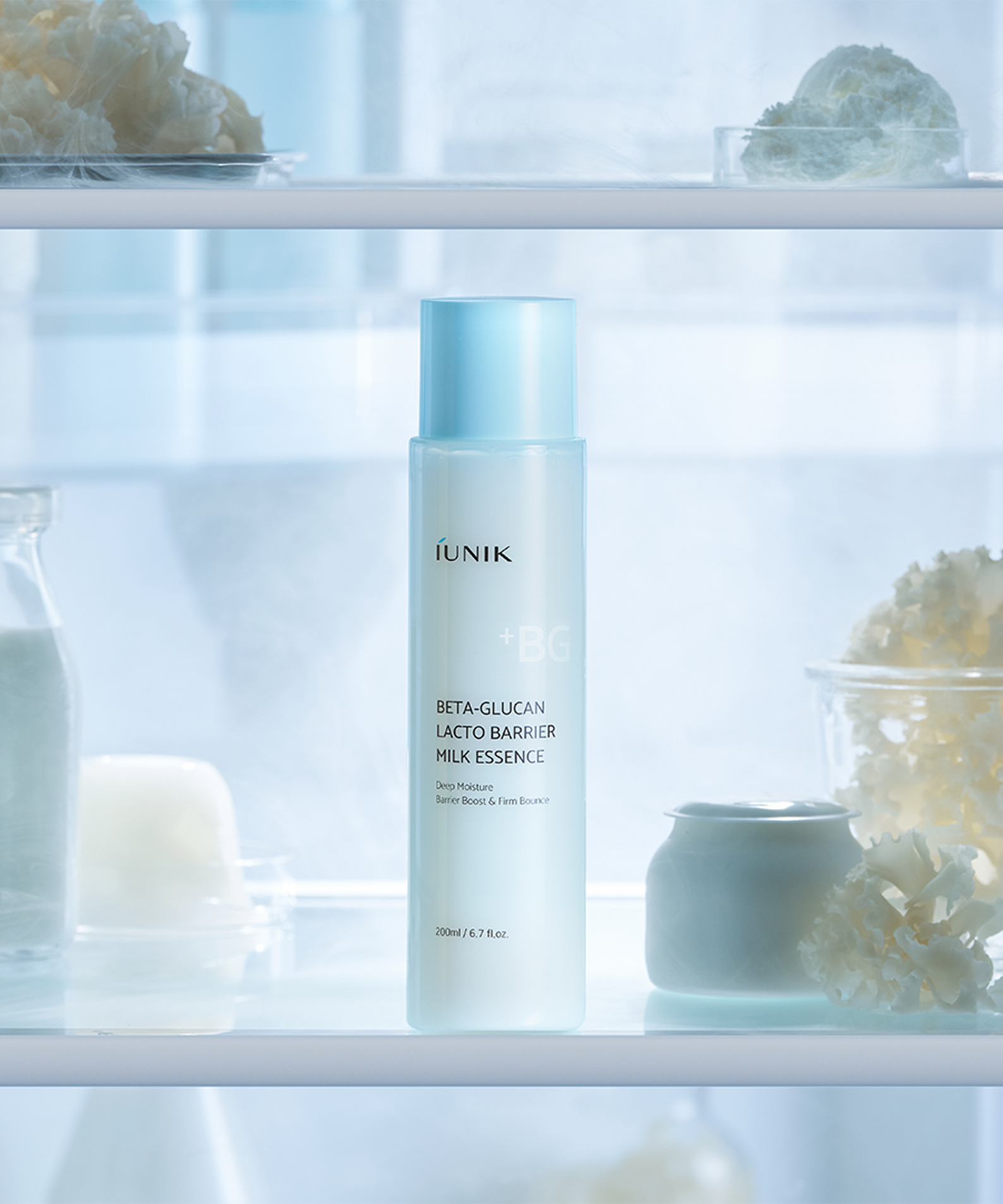 IUNIK Beta Glucan Lactobarrier Milk Essence 200ml, flacon dans un décor spa lumineux, arrière-plan soins et potions