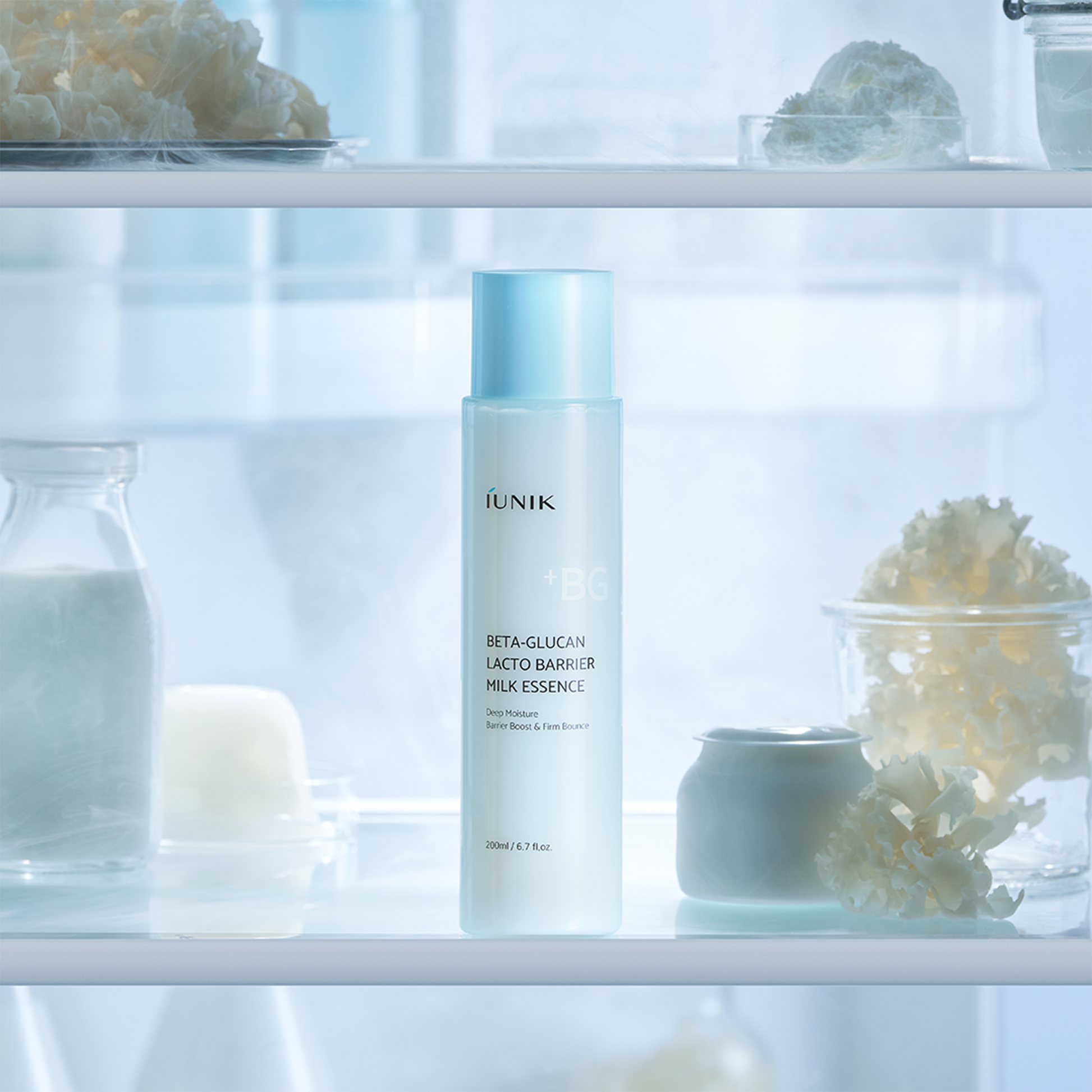 IUNIK Beta Glucan Lactobarrier Milk Essence 200ml, flacon dans un décor spa lumineux, arrière-plan soins et potions