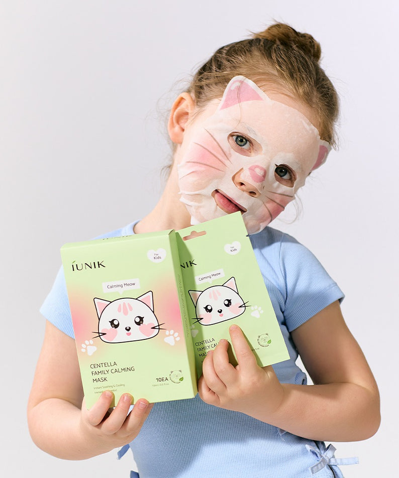 Enfant portant le IUNIK Centella Family Calming Mask for Kids (10 sheets) masque relaxant, avec emballage en mains, idéal pour apaiser la peau.